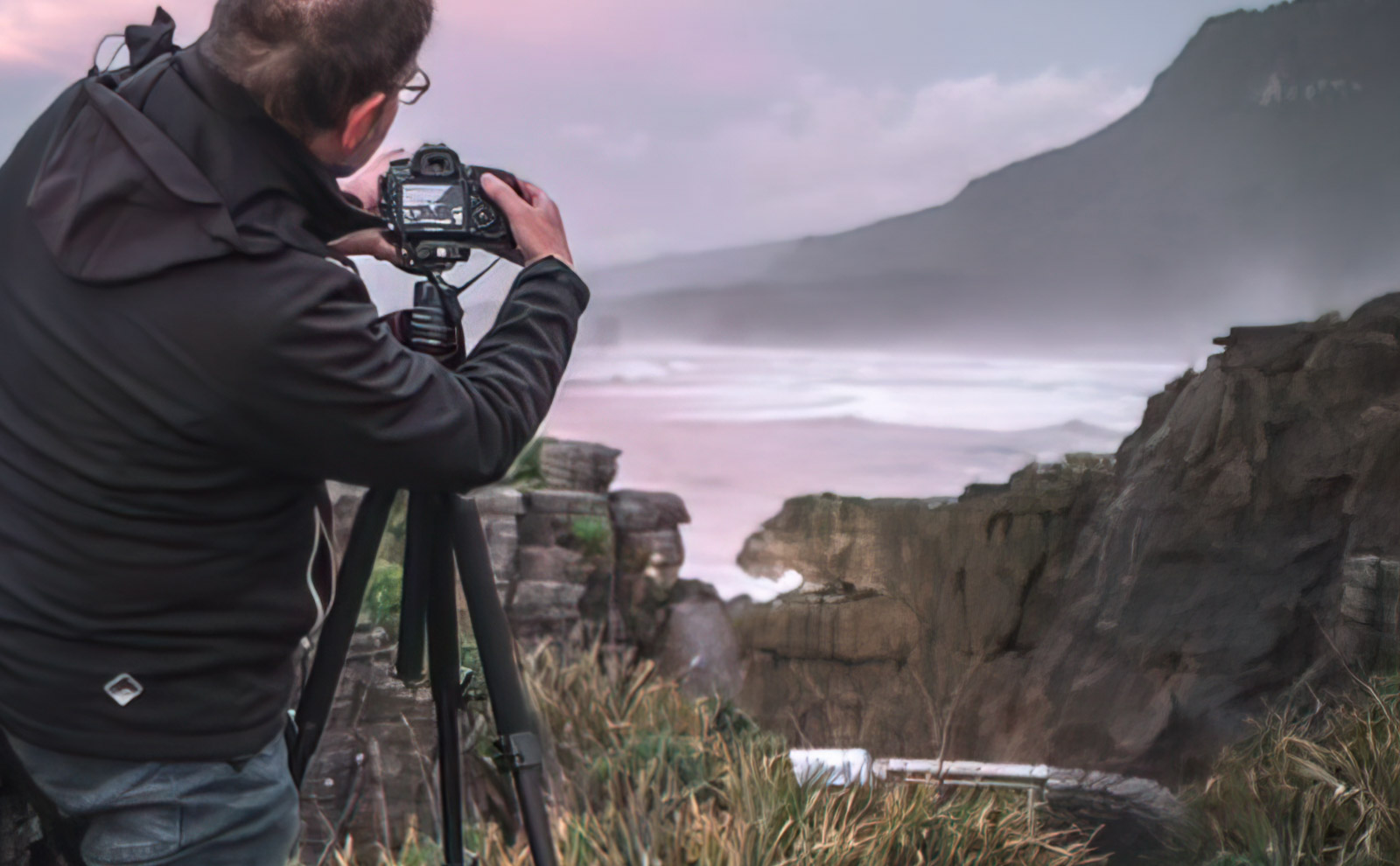 Fotograf mit Stativ bei den Pancake Rocks mit Blick Richtung Punakaiki Beach